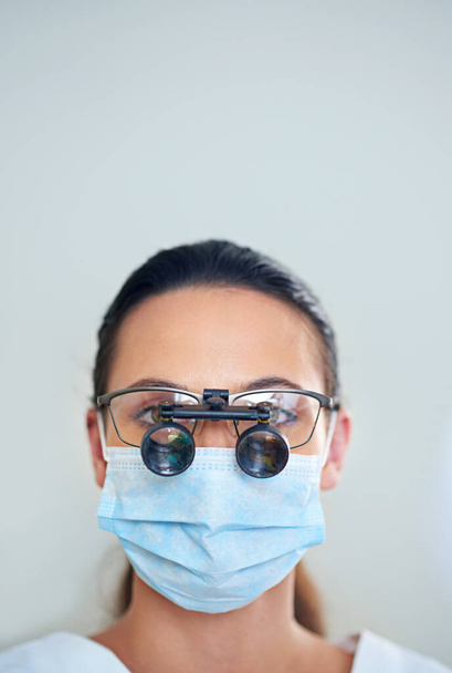 Давайте взглянем поближе. Портрет молодой женщины-стоматолога в увеличительных очках. - Фото, изображение