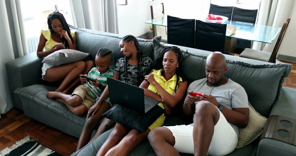 Afrikai család szülők és a gyermekek a technológia otthon kanapé - Fotó, kép