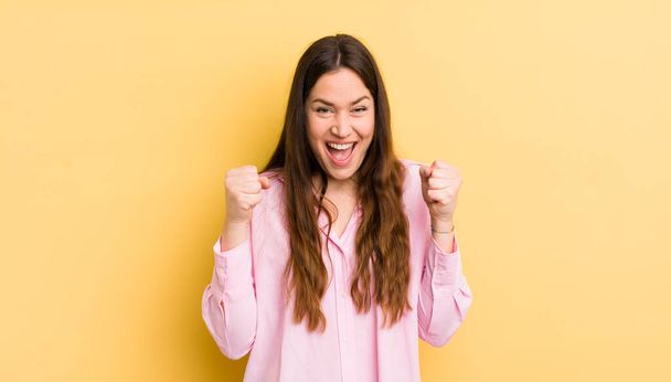 pretty caucasian woman feeling shocked, excited and happy, laughing and celebrating success, saying wow! - Foto, Imagen