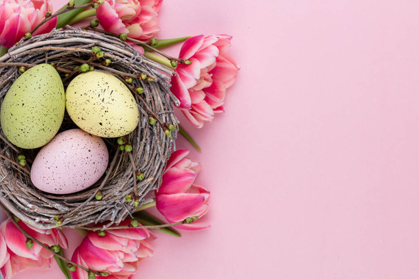 Spring greeting card. Easter eggs in the nest. Spring flowers tulips. - Fotó, kép