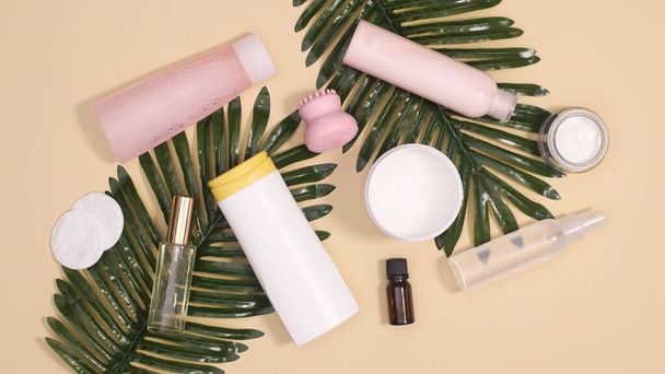 Spa skin care and cosmetics products with natural palm leaves on pastel beige background. Flat lay - Foto, Imagem