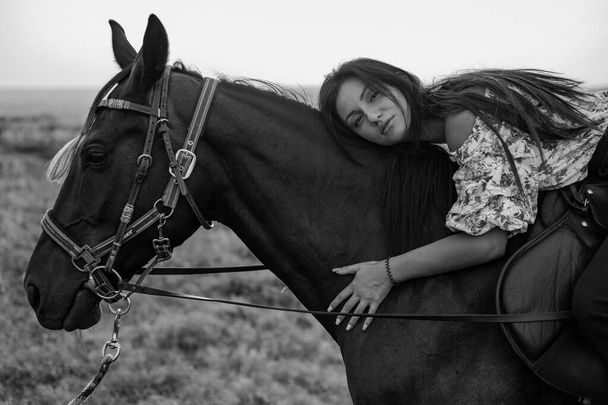 Mädchen mit langen schwarzen Haaren auf dem Land. Ipadrome mit Pferden. Ländliche Landschaften, wilder Westen. - Foto, Bild