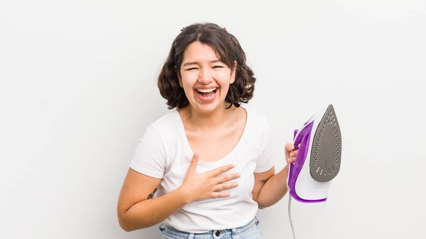 Una ragazza ispanica che ride ad alta voce per una battuta divertente. concetto di lavanderia - Foto, immagini