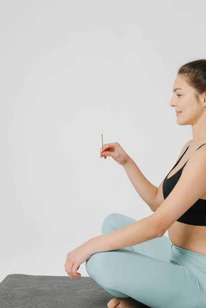 Cropped photo of sporty young woman doing yoga practice isolated on white wall. - 写真・画像