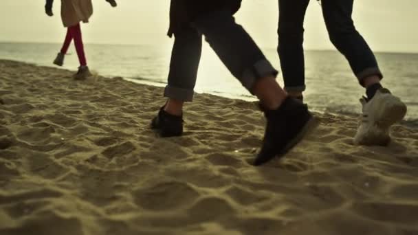 Emberek lábak lépkedő strand naplemente tengeri természet. Család séta homokos part. - Felvétel, videó