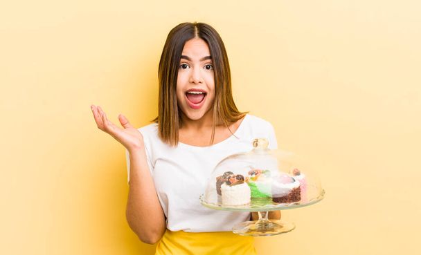 pretty hispanic girl feeling happy, surprised realizing a solution or idea. home made cakes concept - Photo, Image