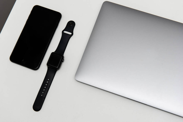 Laptop s hodinami a mobilním telefonem na bílém pozadí - Fotografie, Obrázek