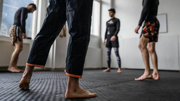Close up on leg of unknown man at brazilian jiu jitsu bjj training copy space martial arts concept - Foto, afbeelding