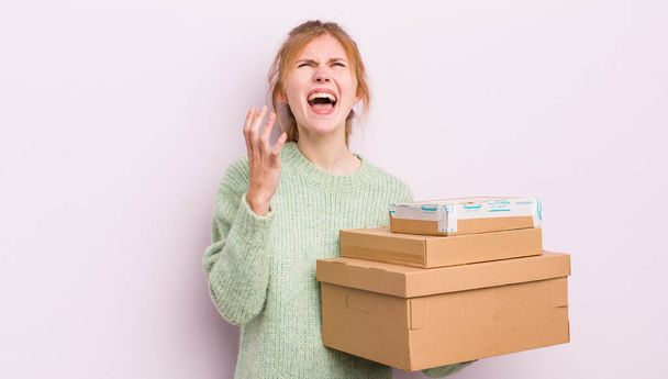 redhead pretty girl looking desperate, frustrated and stressed. shipping boxes concept - Foto, Imagem