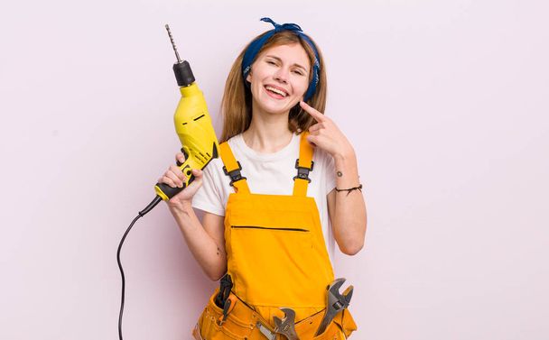 redhead pretty girl smiling confidently pointing to own broad smile. home renovation concept - Photo, image