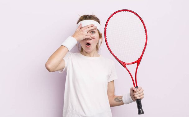 redhead pretty girl looking shocked, scared or terrified, covering face with hand. tennis concept - Zdjęcie, obraz