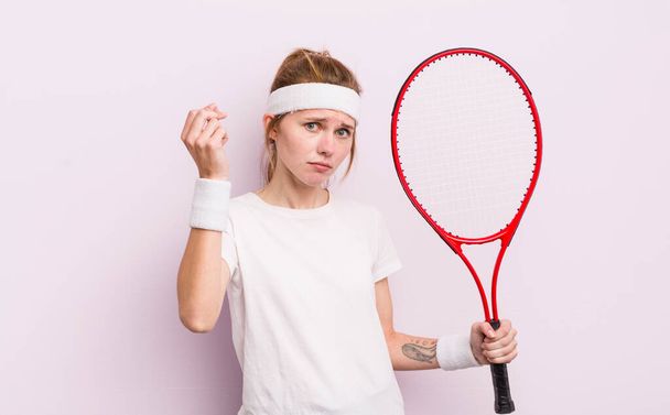 redhead pretty girl making capice or money gesture, telling you to pay. tennis concept - Foto, Imagen