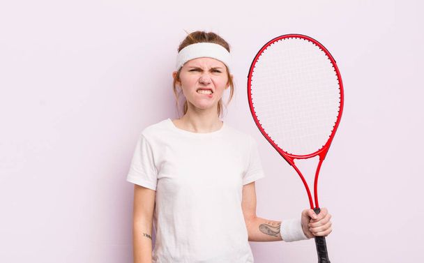 redhead pretty girl looking puzzled and confused. tennis concept - 写真・画像