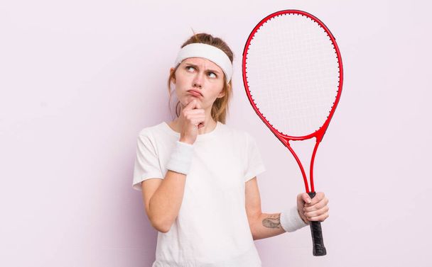 redhead pretty girl thinking, feeling doubtful and confused. tennis concept - Valokuva, kuva