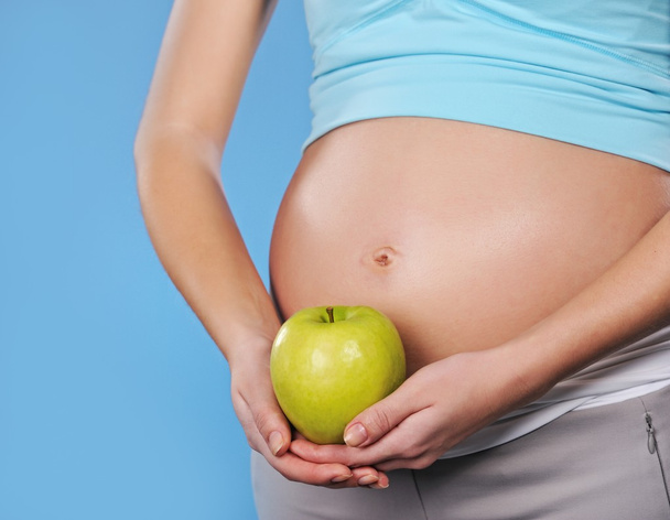 Mujer embarazada con manzana verde
 - Foto, Imagen