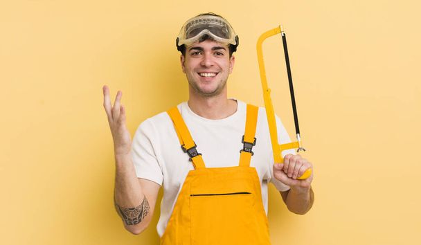 young handsome man feeling happy, surprised realizing a solution or idea. handyman concept - Photo, Image