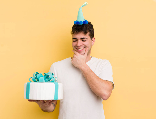 young handsome man smiling with a happy, confident expression with hand on chin. birthday  concept - Fotografie, Obrázek