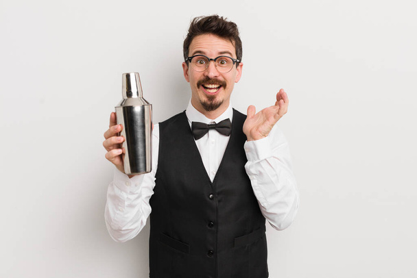 young handsome man feeling happy and astonished at something unbelievable. cocktail bartender - 写真・画像