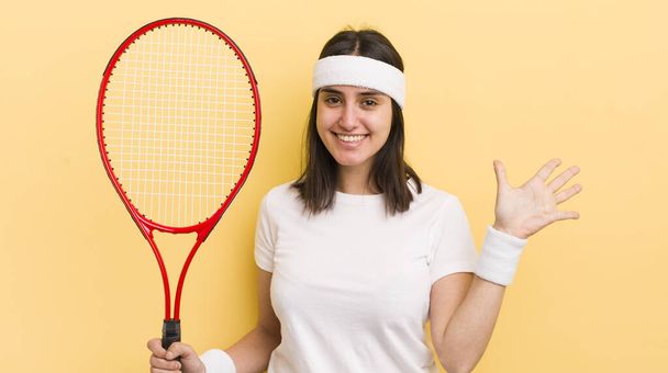 young hispanic woman smiling and looking friendly, showing number five. tennis concept - Фото, зображення
