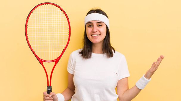 young hispanic woman feeling happy, surprised realizing a solution or idea. tennis concept - 写真・画像