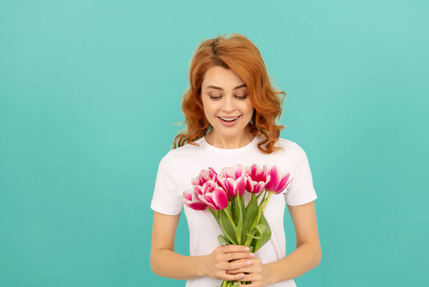 smiling woman with tulip flower bouquet on blue background - Фото, изображение