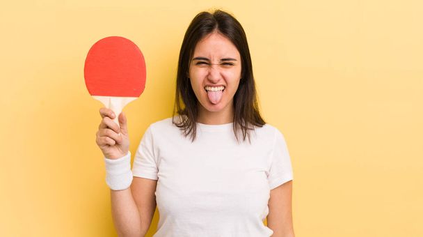 young hispanic woman with cheerful and rebellious attitude, joking and sticking tongue out. ping pong concept - Foto, immagini