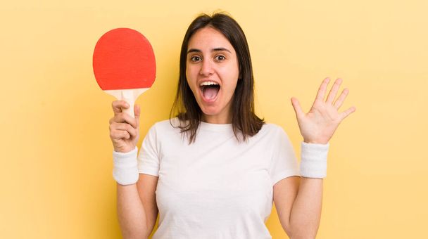 young hispanic woman smiling and looking friendly, showing number five. ping pong concept - Foto, immagini