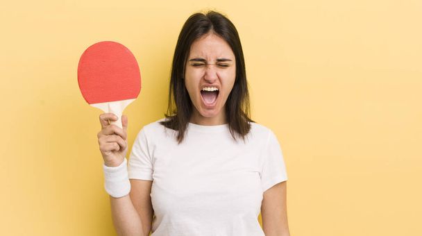 young hispanic woman shouting aggressively, looking very angry. ping pong concept - Foto, immagini