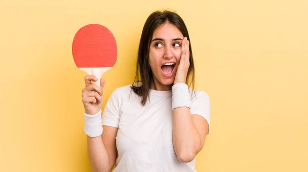young hispanic woman feeling happy, excited and surprised. ping pong concept - Foto, Imagem