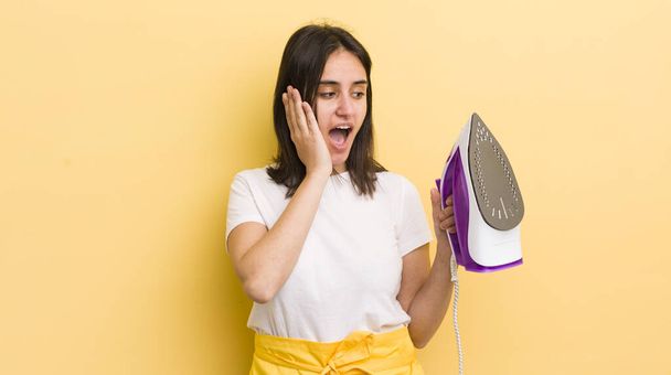young hispanic woman feeling happy, excited and surprised. clothes iron concept - Zdjęcie, obraz