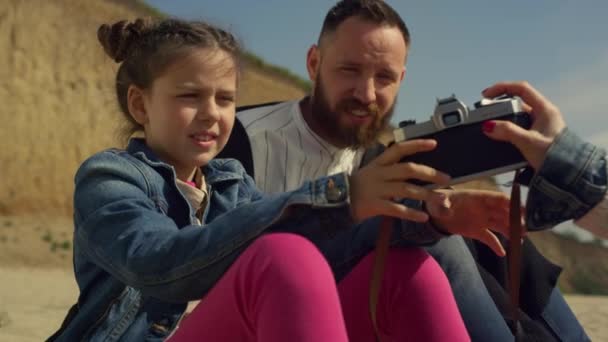 Adorable girl taking photos on beach. Child hold camera on family vacation trip. - Footage, Video