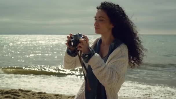 Spanyol nő fényképez a tengerparton. Csinos hölgy fényképezés természet. - Felvétel, videó