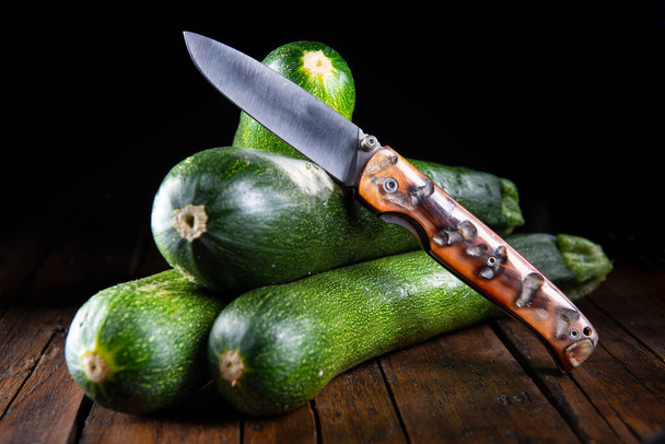 Fresh zucchini on a wooden table in the kitchen - Фото, зображення