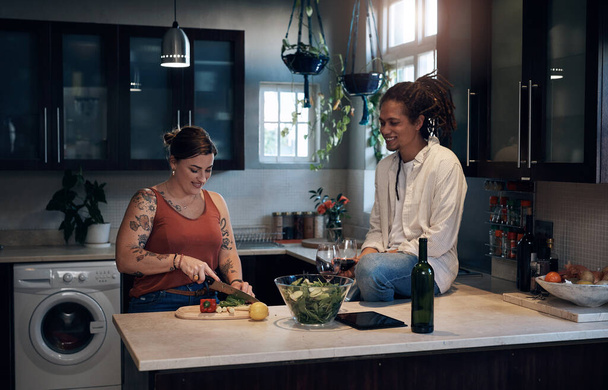 Готовлю здоровый ужин. Съемка молодой пары, стоящей на кухне во время приготовления салата. - Фото, изображение