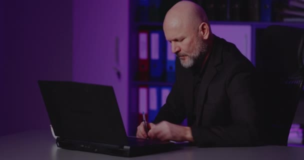 Uomo d'affari oberato di lavoro sul computer portatile in ufficio - Filmati, video