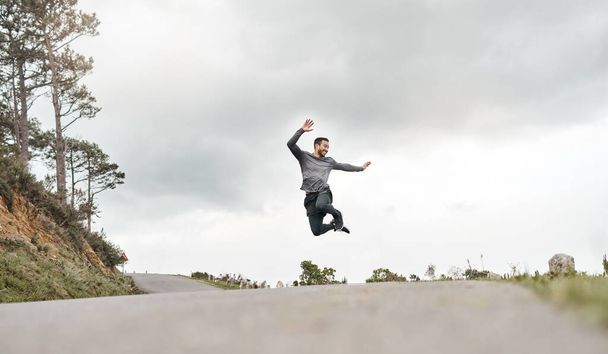 Я щойно побив свій власний рекорд. Повнометражний знімок красивого молодого чоловіка, який стрибає з радістю після ранкового бігу на відкритому повітрі
. - Фото, зображення