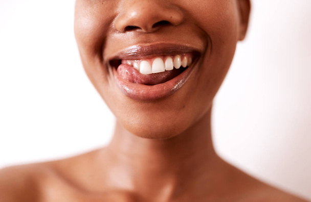 Meine Zähne sahen nie so gut aus. Nahaufnahme einer schönen jungen Frau, die mit glänzenden Lippen vor weißem Hintergrund posiert. - Foto, Bild