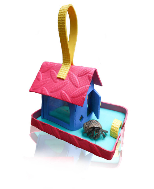 miniatuur kinderspeelgoed huis gemaakt van gebruikt tapijt, op een witte achtergrond - Foto, afbeelding