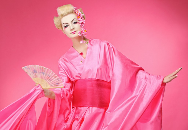 Beautiful geisha with a fan - Фото, зображення