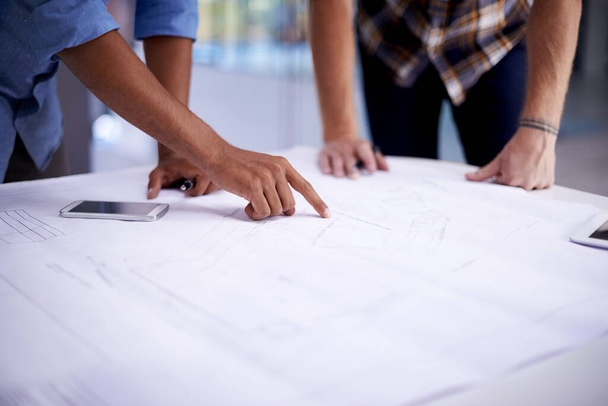 Creating great things together. Closeup shot of two young architects working on blueprints in an office. - Фото, зображення