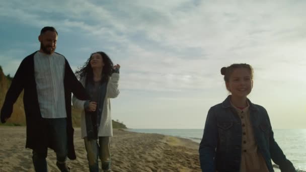 Podekscytowana rodzina kochająca plażę natura przy zachodzie słońca morze. Szczęśliwi ludzie grupa chodzić wybrzeże. - Materiał filmowy, wideo