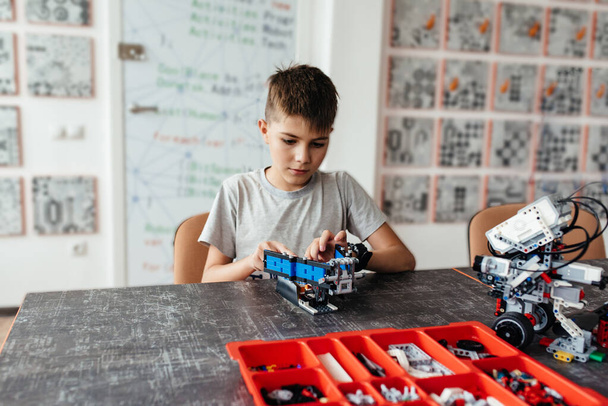 Child plays with a robotic toy assembled from the designer - Foto, immagini