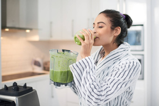 Theres no better way to start your day. Cropped shot of a woman drinking a smoothie at home. - Photo, Image