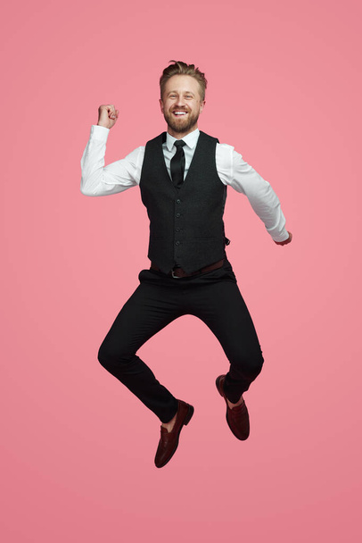 Happy businessman jumping and smiling - Zdjęcie, obraz
