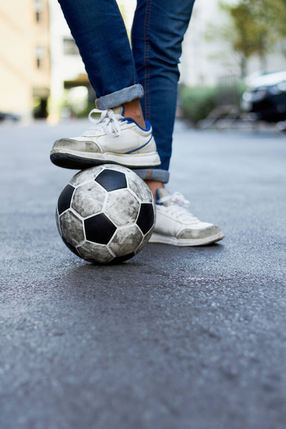 He always scores. Cropped image of a mans foot on a soccer ball in the street. - Photo, Image