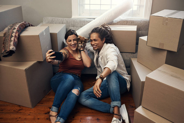 This one is for our album. Shot of a young couple taking a selfie while busy moving into their new home. - Photo, Image