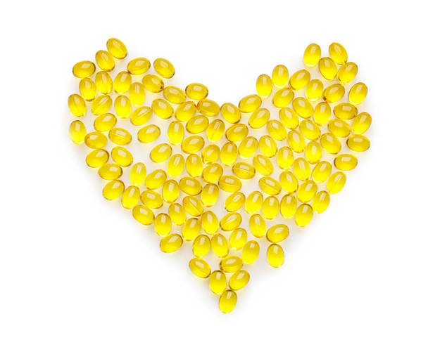 Herzform aus gelben Pillen auf weißem Hintergrund - Foto, Bild