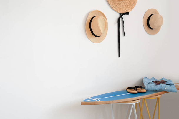 Intérieur de la chambre élégante moderne avec planche de surf, chapeaux et accessoires féminins - Photo, image