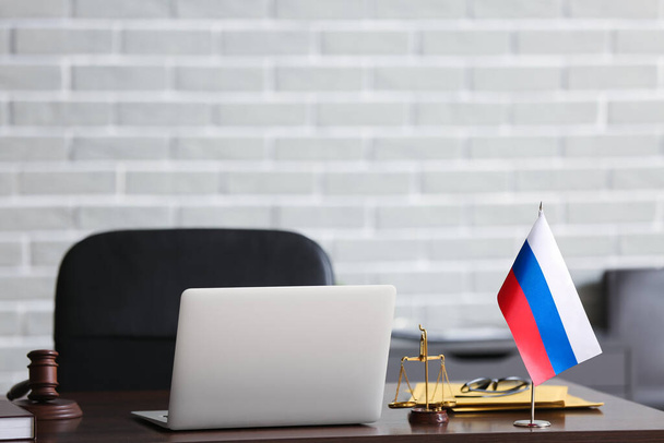 Portatile moderno, martelletto giudice, bilancia e bandiera russa sul tavolo in carica - Foto, immagini