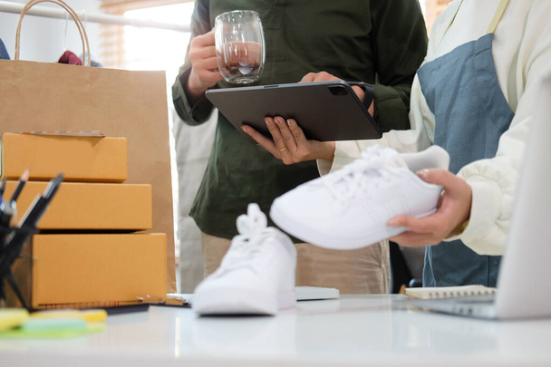 Indítsa el a kisvállalkozás tulajdonosa ellenőrizze a termék vásárlási megrendelés digitális tabletta és előkészíti a csomag dobozok termék szállításra. - Fotó, kép
